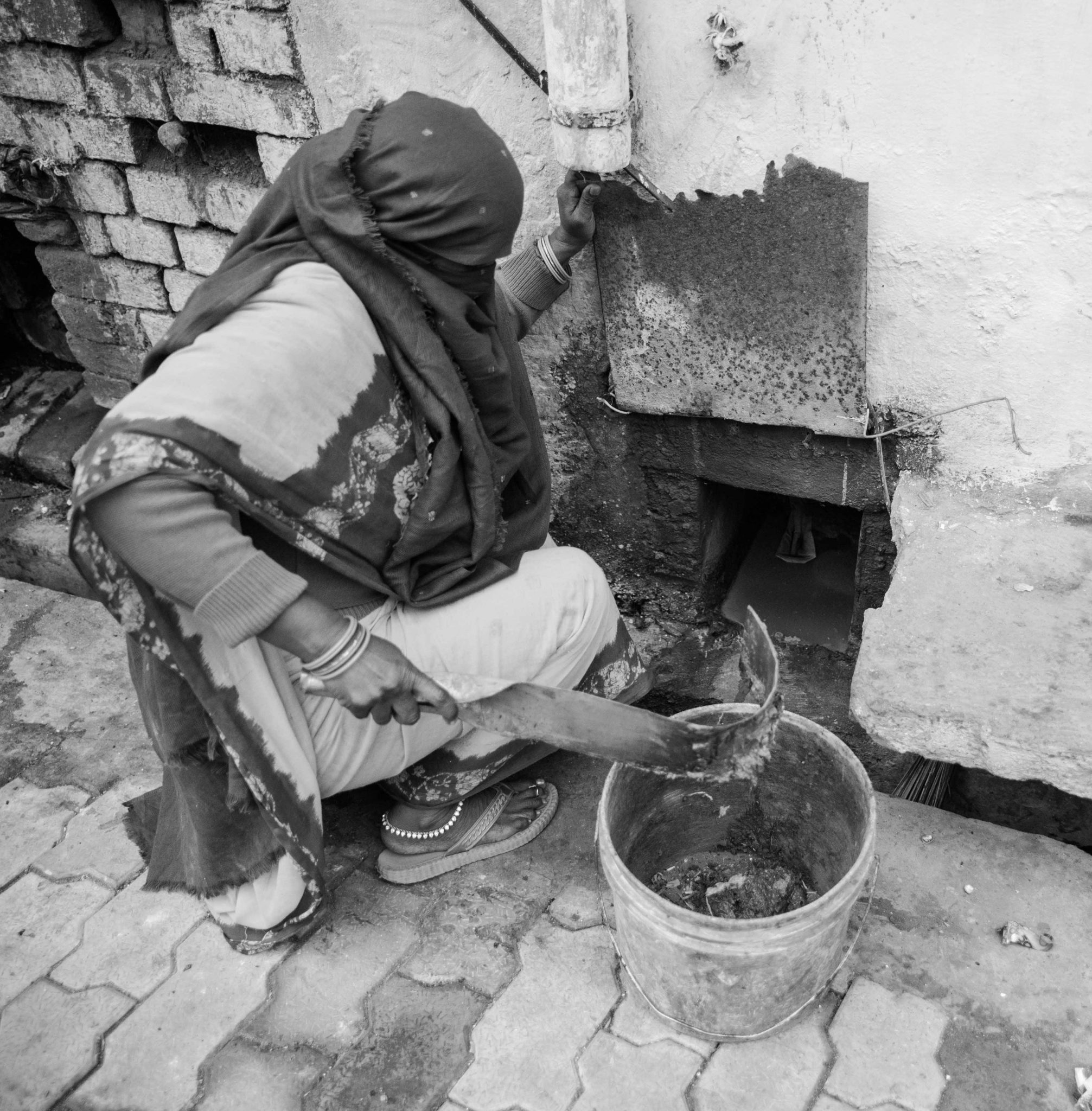 Vasumati cleans a household latrine